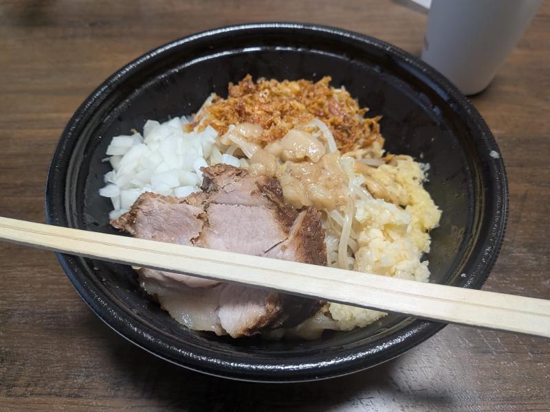 机の上に置かれた汁無しラーメンの写真